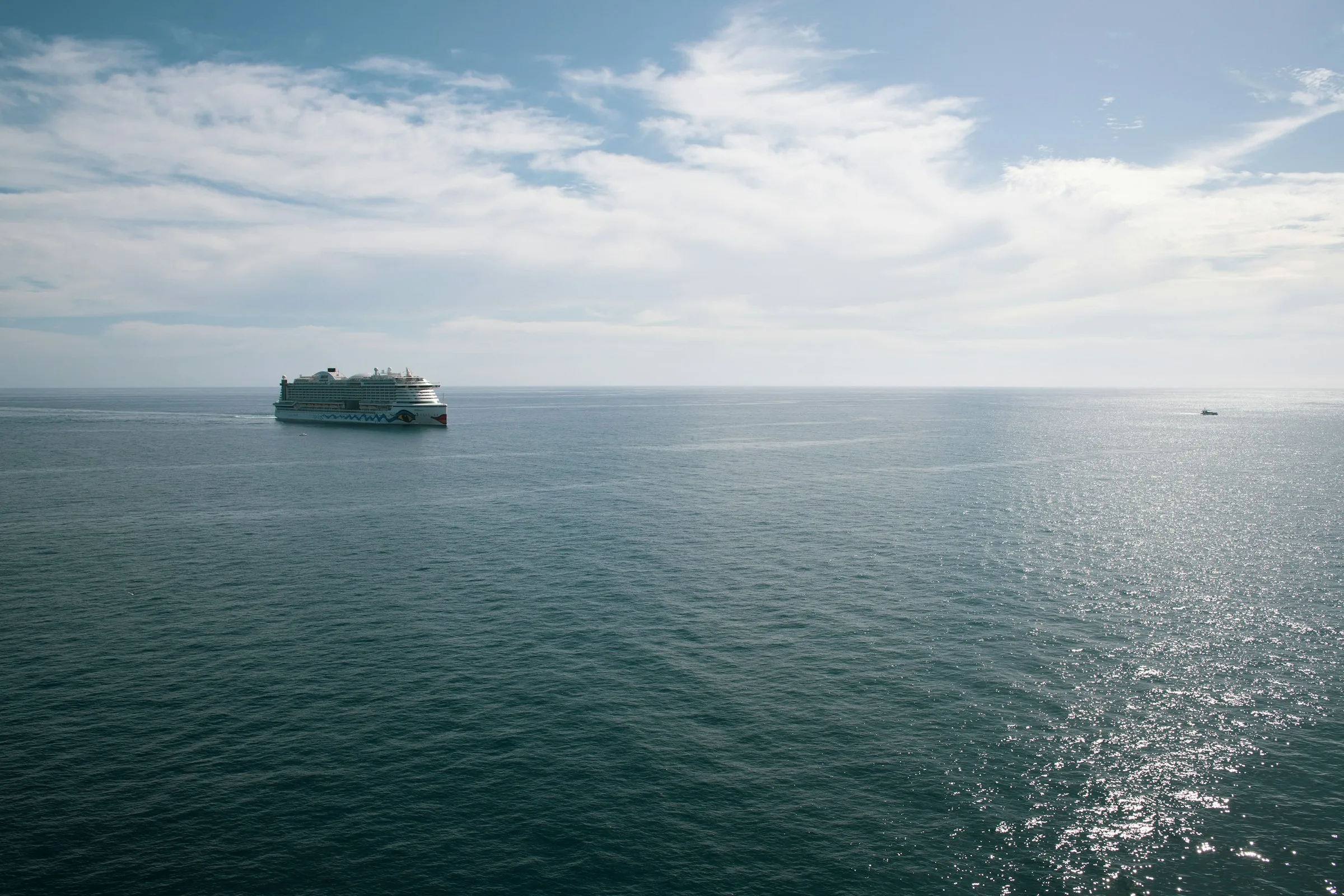 Polar expedition cruise ship at sea with calm blue ocean stretching to the horizon